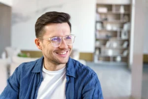 Young man smiles away from the camera in a modern home setting