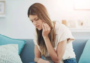 Woman at home experiencing wisdom tooth pain