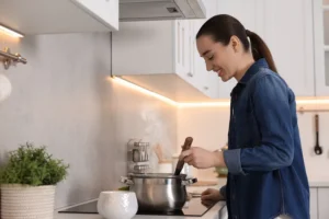 Young woman making soup at home